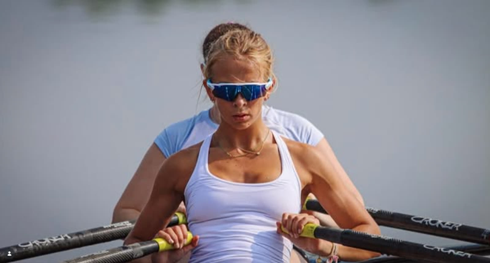 A rower at full focus, hands on the oars